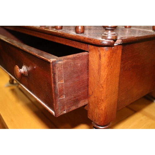 573 - A mahogany canterbury, fitted one drawer, on turned and castored supports, 20