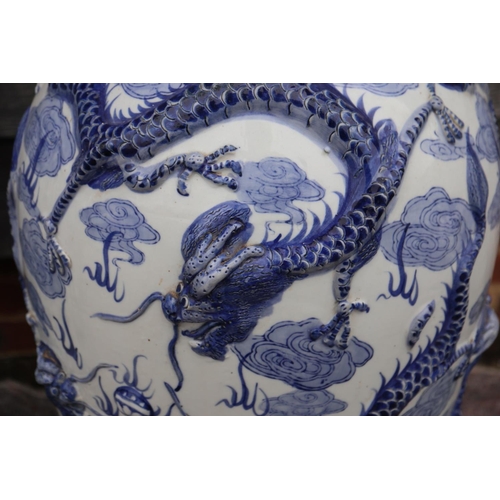 106 - A pair of Chinese blue and white relief decorated dragon vases, 36