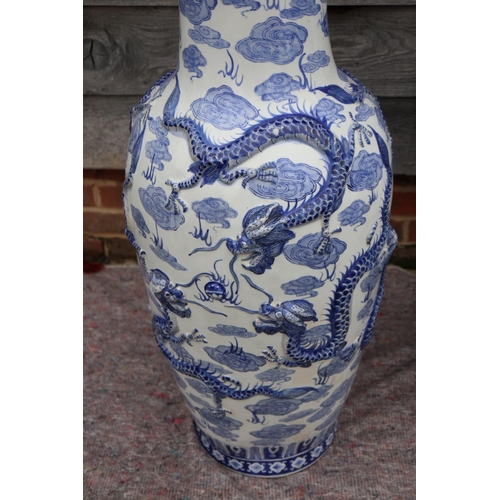 106 - A pair of Chinese blue and white relief decorated dragon vases, 36