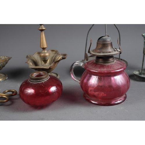 152 - A pair of brass candlesticks with shell-shaped wax drip trays, a ruby glass hand-held oil lamp, a si... 