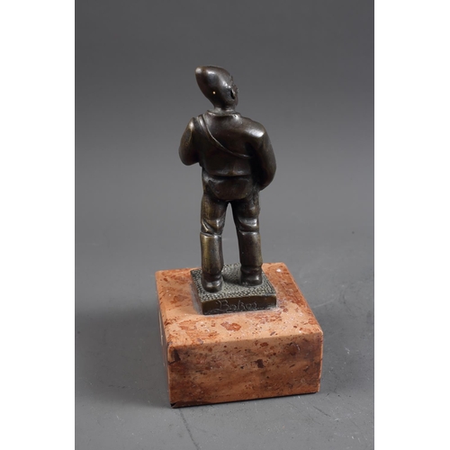 159 - Bokos: a patinated bronze figure of a drummer, on pink marble base, 10