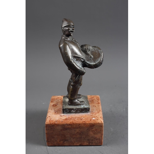 159 - Bokos: a patinated bronze figure of a drummer, on pink marble base, 10