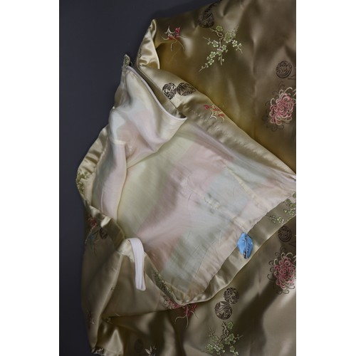 207 - A woman's Chinese tailor-made suit in a gold patterned satin, jacket size 12/14, skirt size 8/10, an... 