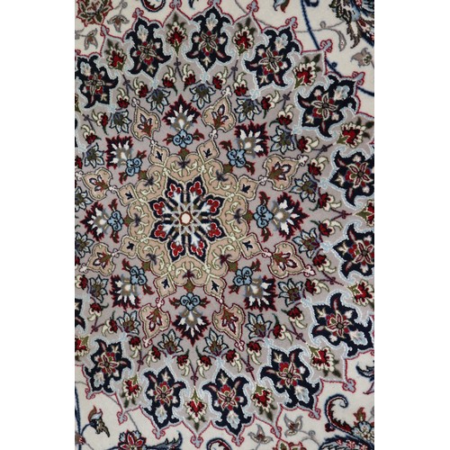 603 - A Persian Isfahan signed carpet of traditional design with all-over scrolls and leaves in shades of ... 