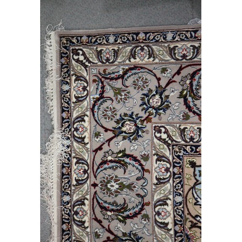 603 - A Persian Isfahan signed carpet of traditional design with all-over scrolls and leaves in shades of ... 