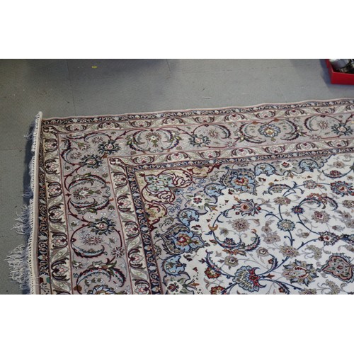 603 - A Persian Isfahan signed carpet of traditional design with all-over scrolls and leaves in shades of ... 