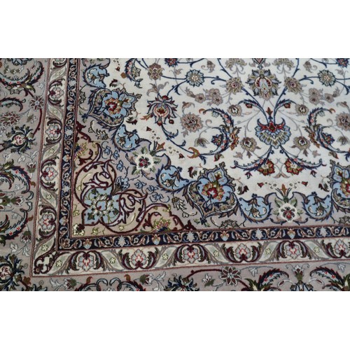 603 - A Persian Isfahan signed carpet of traditional design with all-over scrolls and leaves in shades of ... 