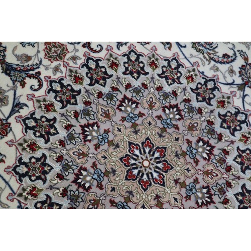 603 - A Persian Isfahan signed carpet of traditional design with all-over scrolls and leaves in shades of ... 