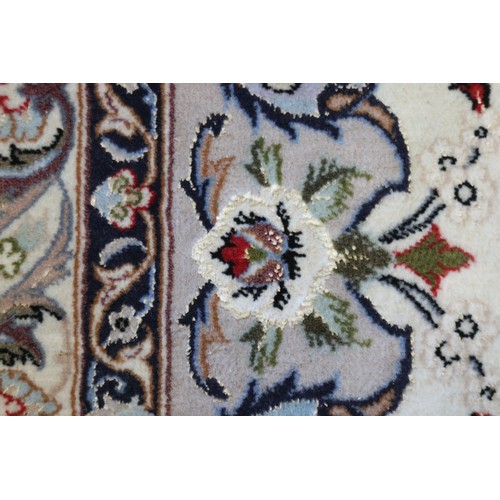 603 - A Persian Isfahan signed carpet of traditional design with all-over scrolls and leaves in shades of ... 