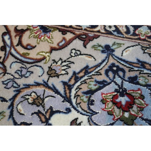 603 - A Persian Isfahan signed carpet of traditional design with all-over scrolls and leaves in shades of ... 