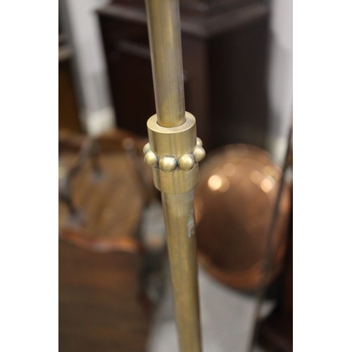 229 - A pair of brass adjustable floor standing reading lights, on circular bases, 45