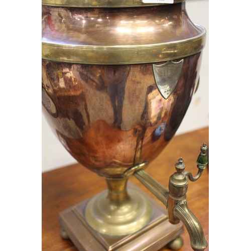 156 - A Georgian copper and brass samovar with silver plaque, on bun feet, 21