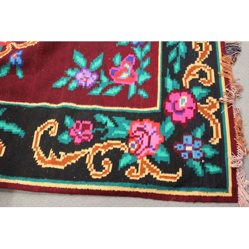 602 - A Kelim style carpet with all-over floral and scroll design and multi-borders in shades of red, plum... 