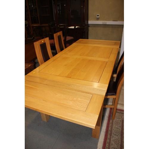 543 - A modern light oak draw leaf dining table, on square supports, 86 1/2