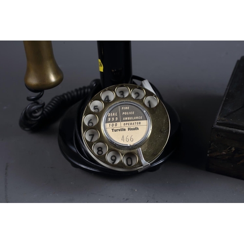 120 - A rotary candlestick black and brass mounted telephone and a slate mantel clock with enamelled dial ... 