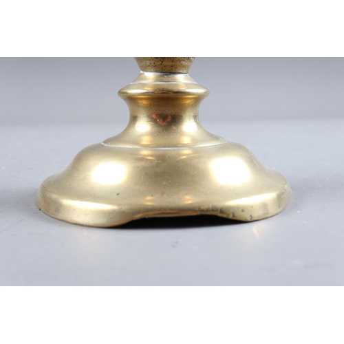 152 - A 17th century brass candlestick with broad drip pan, 8 1/4