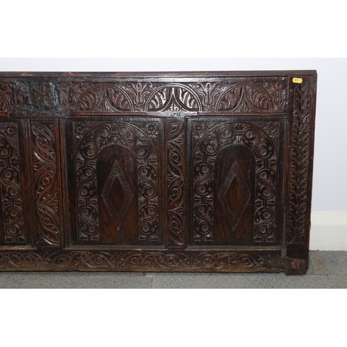 184 - An early 17th century carved oak four panel coffer front with arcade design, 58