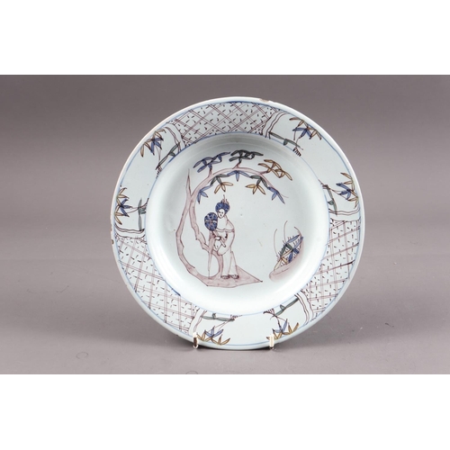 29 - An 18th century Bristol delft plate with manganese and cobalt blue figure decoration and diaper bord... 