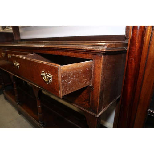 429 - A late 18th century oak dresser, the upper section with open plate shelves over three drawers with b... 