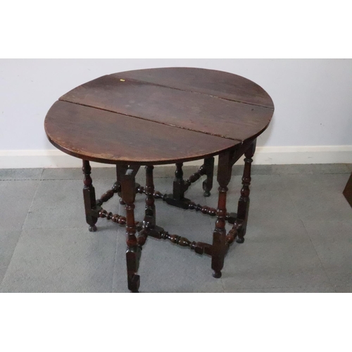 431 - A mid 18th century provincial oak gateleg dining table, on baluster turned and stretchered supports,... 