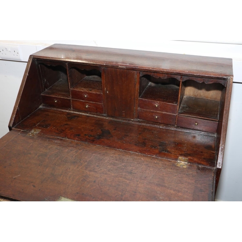 432 - An 18th century oak fall front bureau, the interior fitted drawers and pigeonholes over four long gr... 