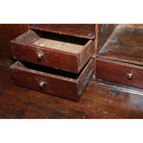 432 - An 18th century oak fall front bureau, the interior fitted drawers and pigeonholes over four long gr... 