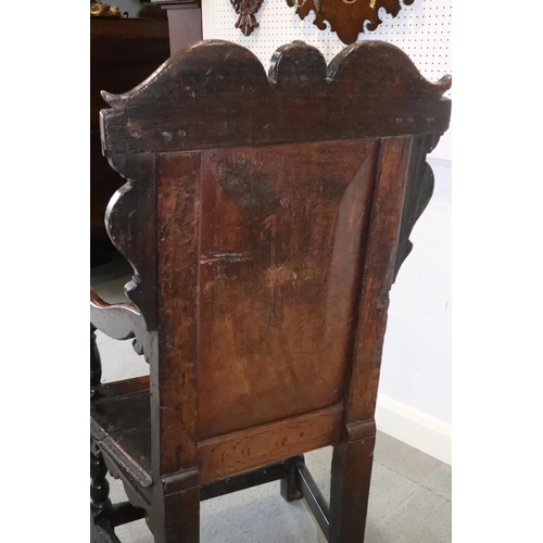 459 - A 17th century carved oak wainscot armchair with scroll panel back, on turned and stretchered suppor... 