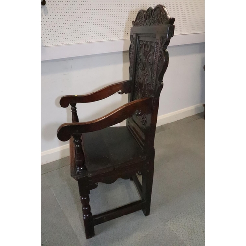 459 - A 17th century carved oak wainscot armchair with scroll panel back, on turned and stretchered suppor... 