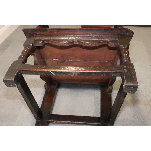 459 - A 17th century carved oak wainscot armchair with scroll panel back, on turned and stretchered suppor... 