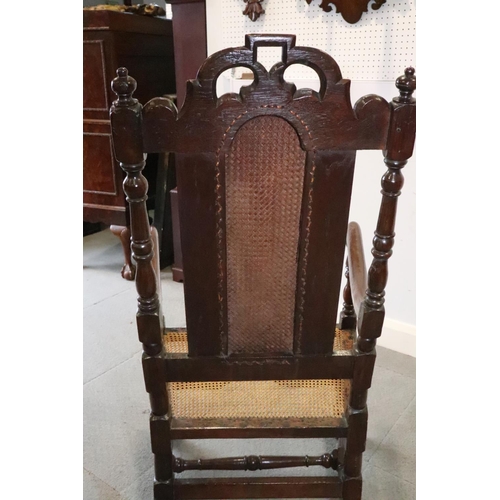 463 - A late 17th century carved oak open armchair with padded back and cane seat, and loose seat cushion,... 