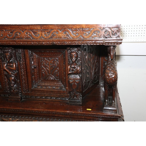 465 - An early 17th century carved oak buffet/court cupboard with griffins, caryatids and herms, frieze ce... 