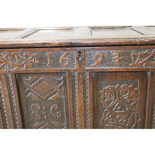 472 - A late 17th century carved oak four panel front coffer, dated 1693, on stile supports, 52