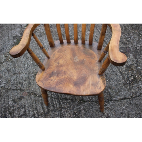 535 - A Windsor lath back farmhouse elbow chair, with elm panel seat, on turned and stretchered supports