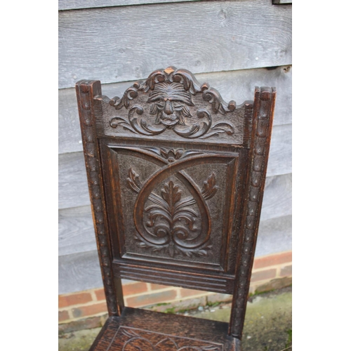 561 - A 17th century style carved oak hall chair with panel seat, on turned and stretchered supports