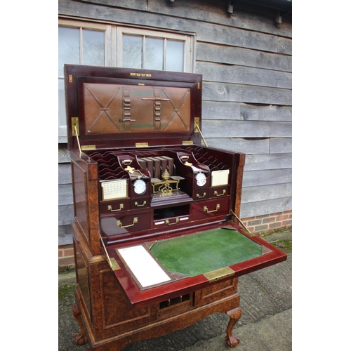 562 - A 1930s burr walnut fall front secretaire desk with fitted interior, including postal scales, barome... 