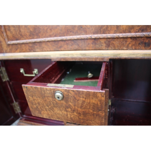 562 - A 1930s burr walnut fall front secretaire desk with fitted interior, including postal scales, barome... 