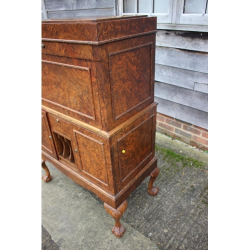 562 - A 1930s burr walnut fall front secretaire desk with fitted interior, including postal scales, barome... 