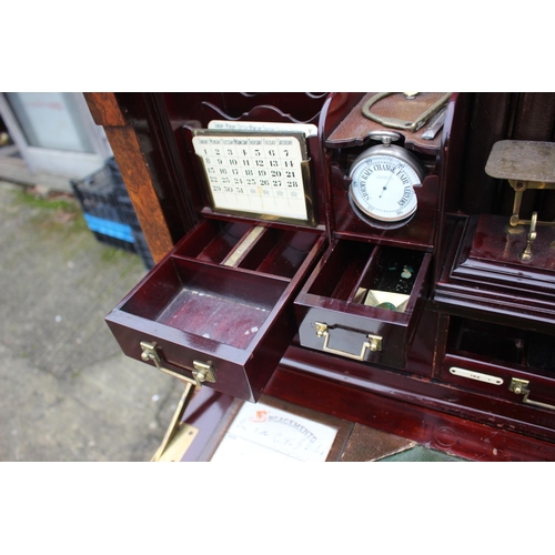 562 - A 1930s burr walnut fall front secretaire desk with fitted interior, including postal scales, barome... 