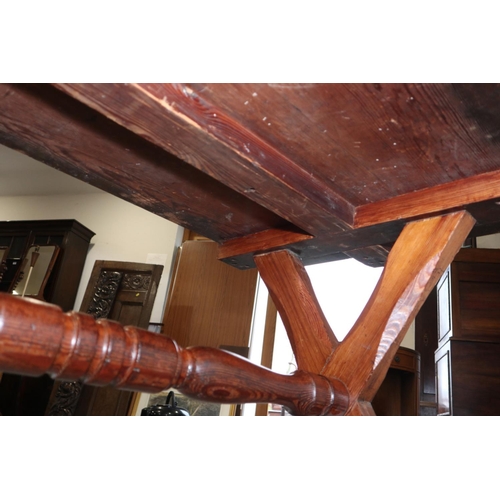 563 - An antique pitch pine refectory table, on chamfered 'X' frame supports, 54