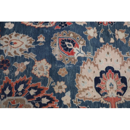 568 - An Indian Burdur wool carpet with all-over palmette design on a blue ground, multi-bordered in shade... 