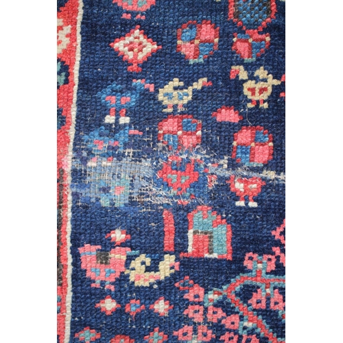 576 - An antique Caucasian/Kurdish rug with all-over tree design on a blue ground (patched, cut and repair... 