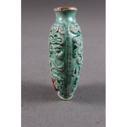 105 - A Chinese green glazed ceramic relief dragon decorated snuff bottle, 2 3/4