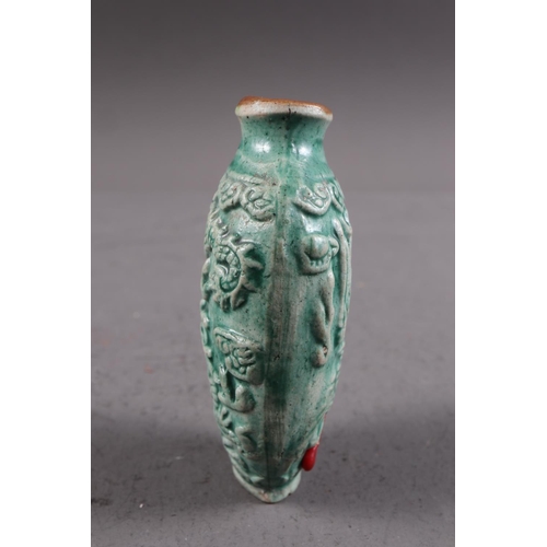 105 - A Chinese green glazed ceramic relief dragon decorated snuff bottle, 2 3/4