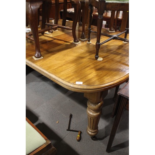 496 - A late 19th century walnut extending dining table with three extra leaves, on turned fluted castored... 