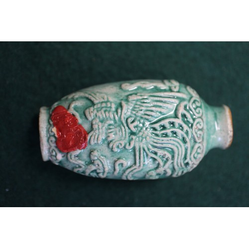 105 - A Chinese green glazed ceramic relief dragon decorated snuff bottle, 2 3/4