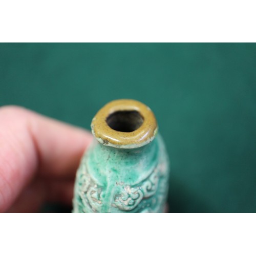 105 - A Chinese green glazed ceramic relief dragon decorated snuff bottle, 2 3/4