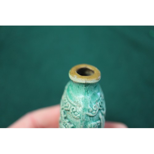 105 - A Chinese green glazed ceramic relief dragon decorated snuff bottle, 2 3/4