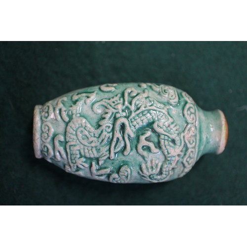 105 - A Chinese green glazed ceramic relief dragon decorated snuff bottle, 2 3/4