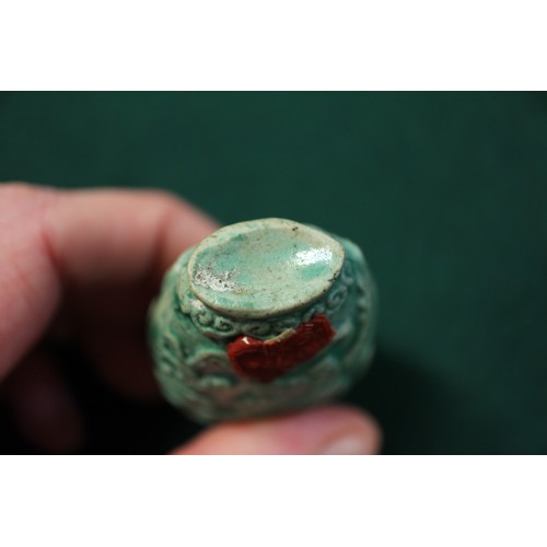 105 - A Chinese green glazed ceramic relief dragon decorated snuff bottle, 2 3/4