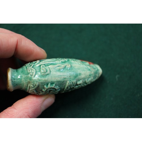 105 - A Chinese green glazed ceramic relief dragon decorated snuff bottle, 2 3/4